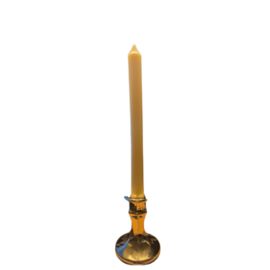 A 25cm beeswax taper candle with a church top in a brass candle holder